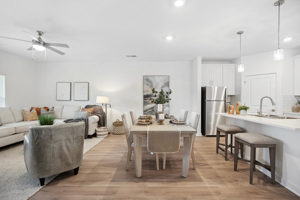 a living room and dining room with a table and chairs