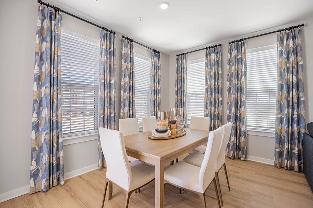 a dining room with white chairs and a wooden table