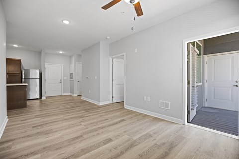 A spacious room with a ceiling fan and lighting.