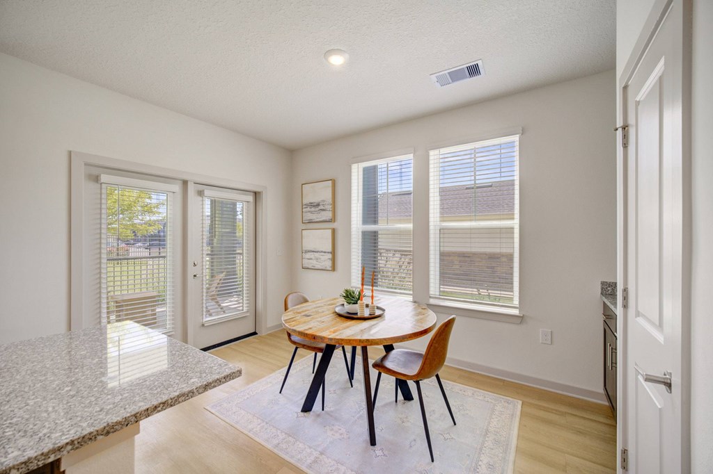 A dining room with a table and chairs.