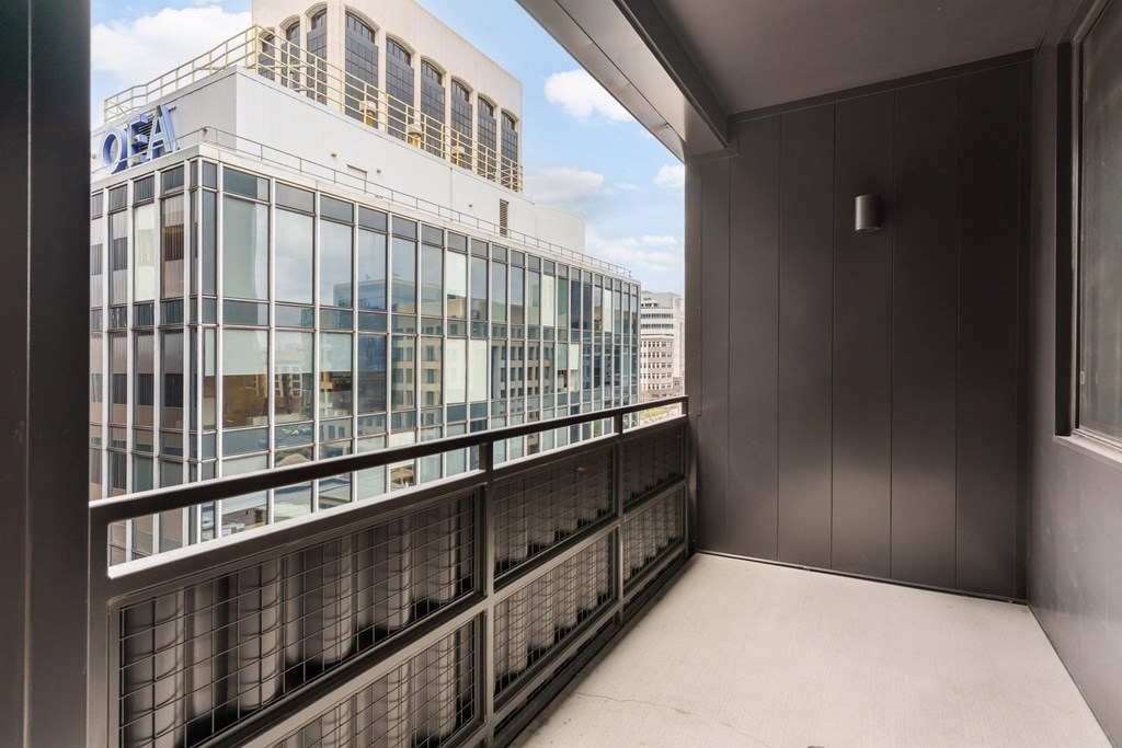 A balcony with a railing and a building in the background.