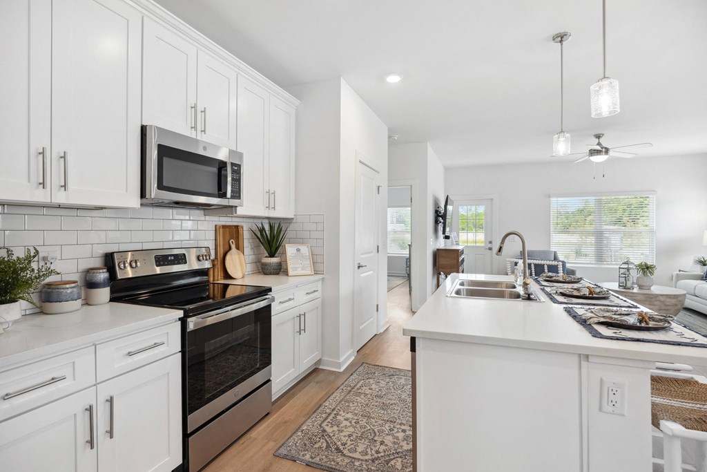 an open kitchen with white cabinets and stainless steel appliances