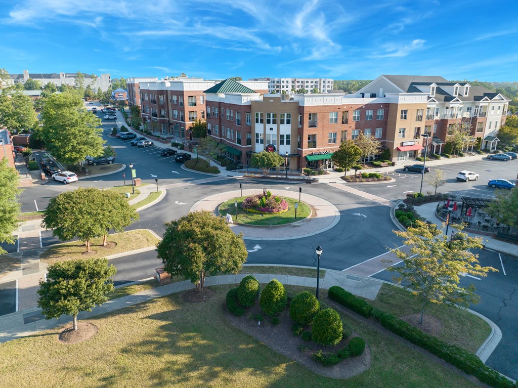 an aerial view of a parking lot with a street and buildings