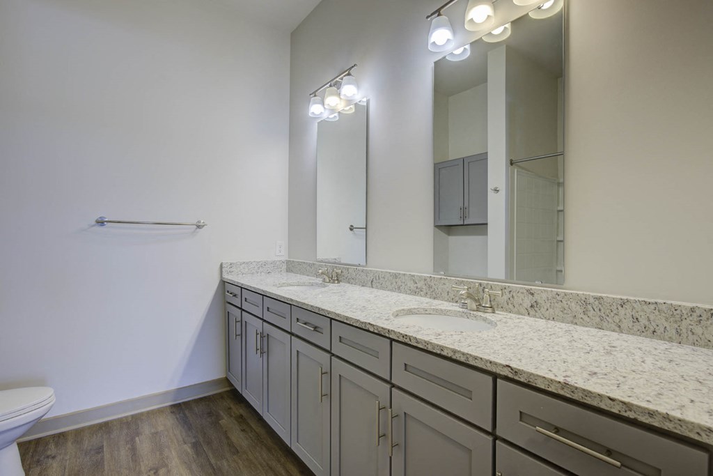 a bathroom with granite counter tops and a large mirror