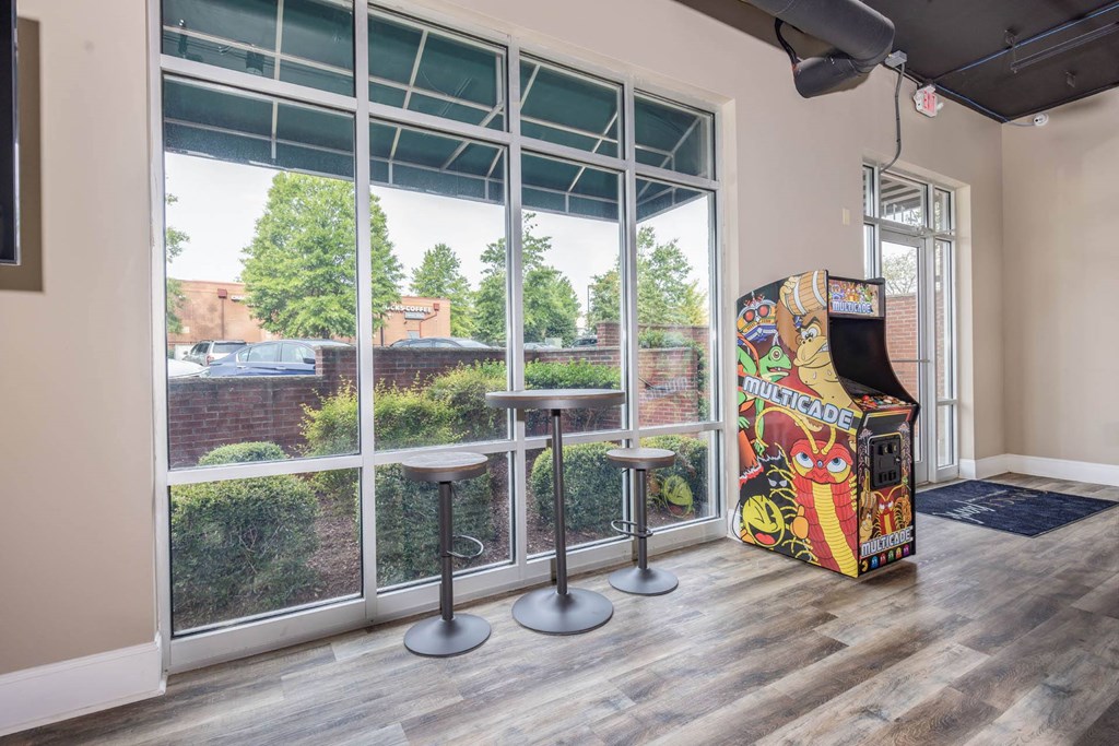 a room with a large window and a board game and some stools