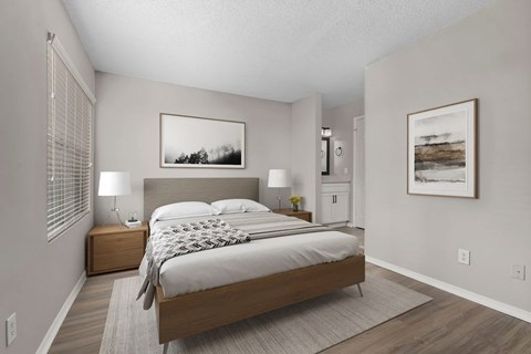 A bedroom with a large bed and two nightstands.