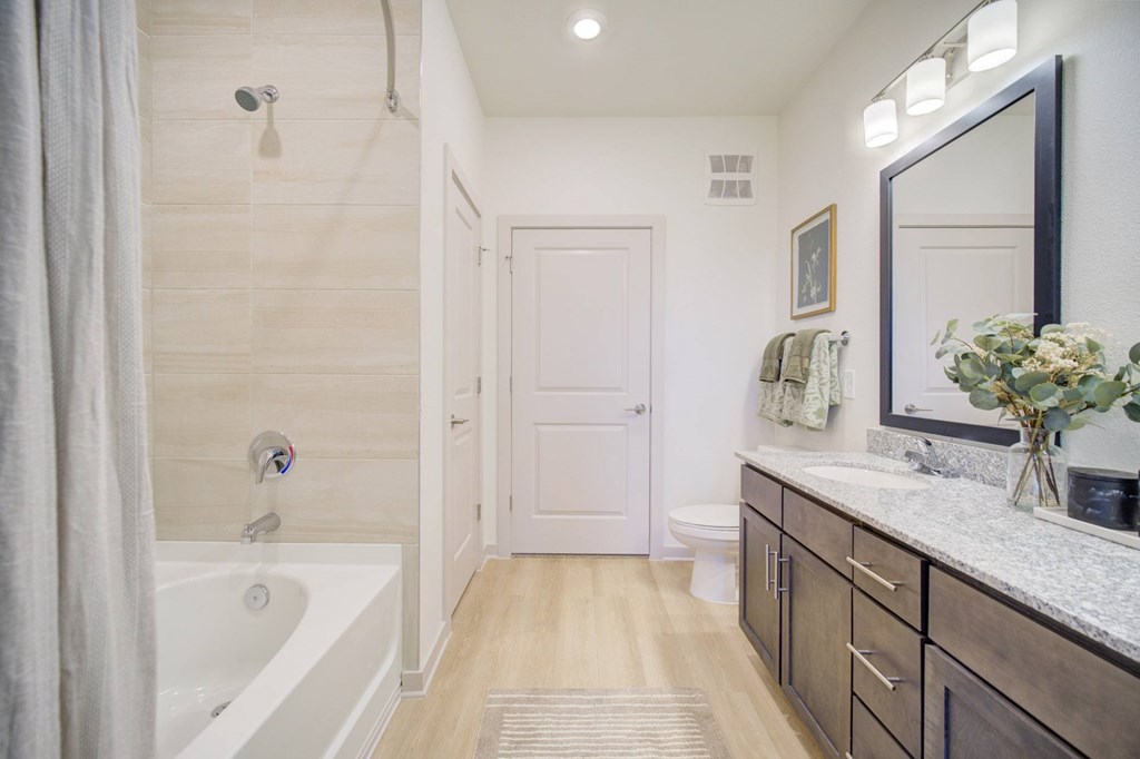 A bathroom with a white tub and a white door.