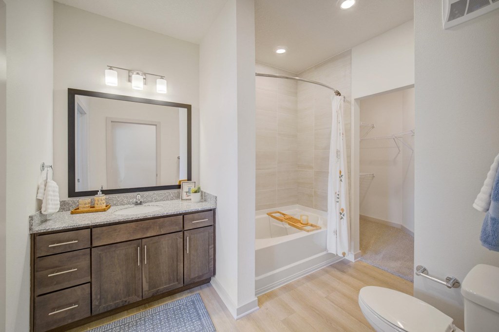 A bathroom with a white toilet, sink, and a mirror.