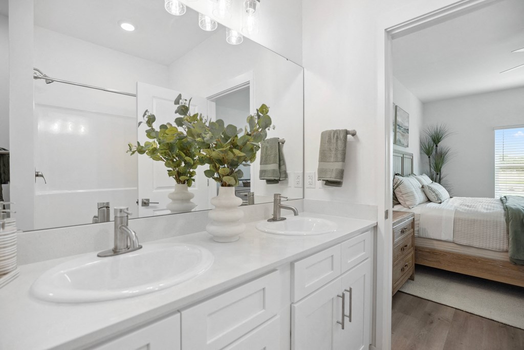a white bathroom with two sinks and a large mirror