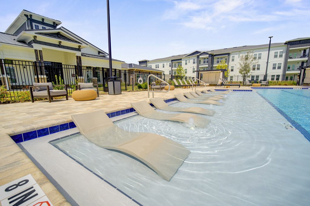 A swimming pool with a slide and a building in the background.