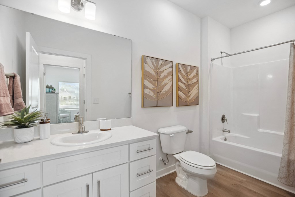 a bathroom with a toilet sink and shower and a mirror