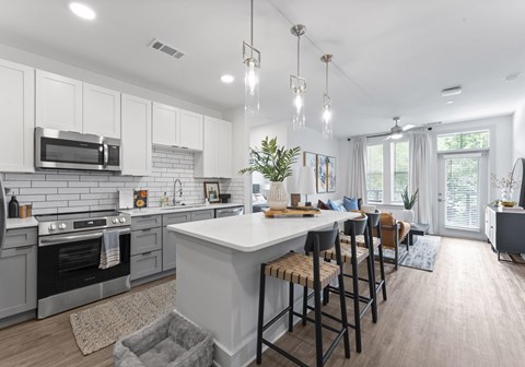A modern kitchen with a large island and bar stools.