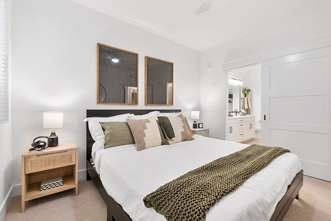 a bedroom with a bed and two mirrors on the wall