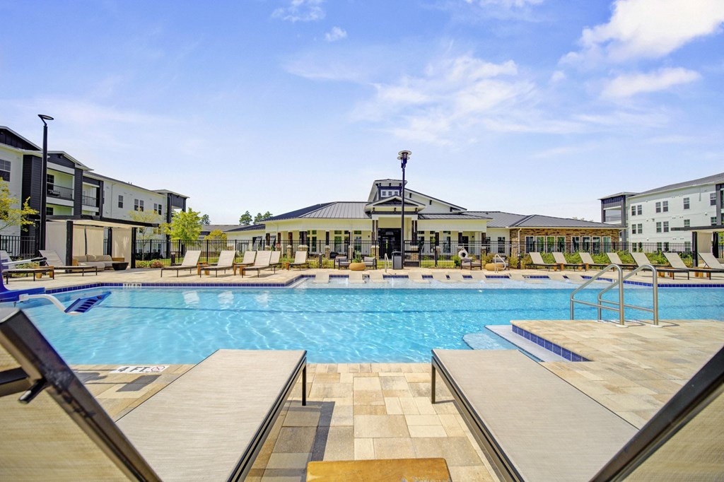 A large swimming pool with a building in the background.
