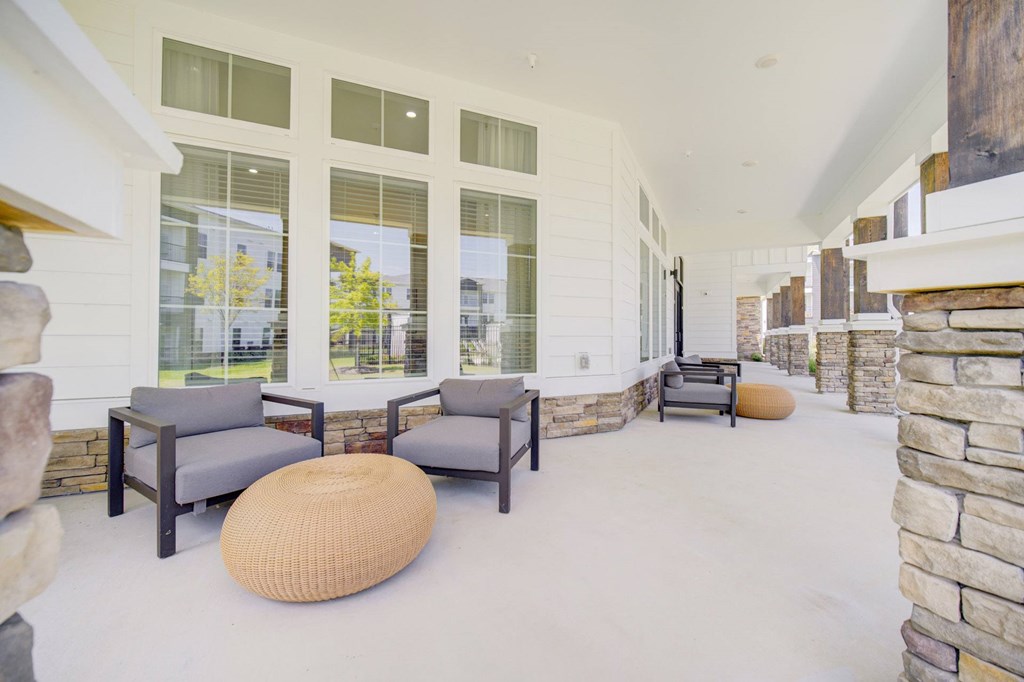 A patio with a couch, chair, and ottoman.