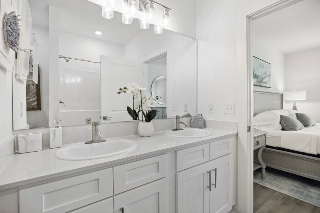 a white bathroom with two sinks and a mirror