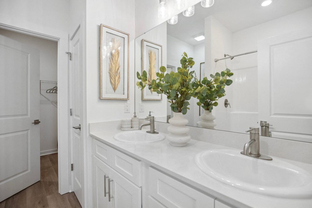 a white bathroom with two sinks and a mirror