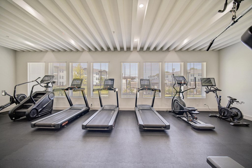 A gym with treadmills, elliptical machines, and stationary bikes.