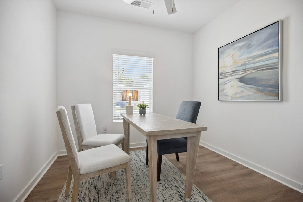 a dining room with a table and chairs and a window