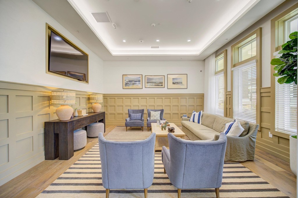 A living room with a striped rug and two blue chairs.