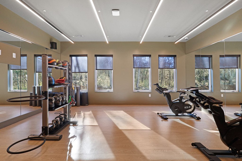 A gym with exercise equipment and windows. at Terraces at High Mountain, Huntsville