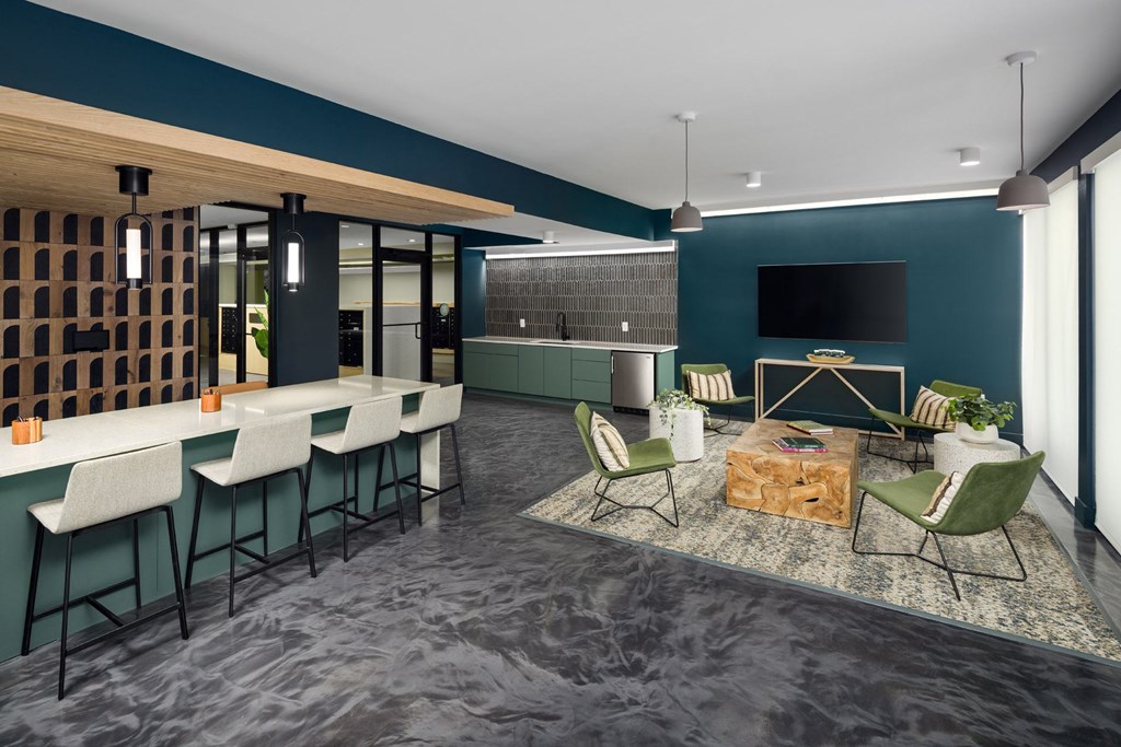 A modern kitchen with a dark blue wall and a wooden ceiling.