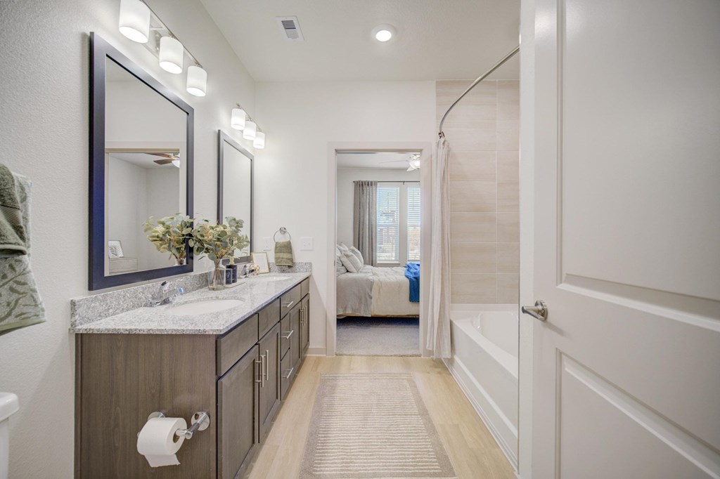 A bathroom with a marble countertop and a large mirror.