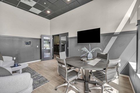 A modern dining room with a grey table and chairs.
