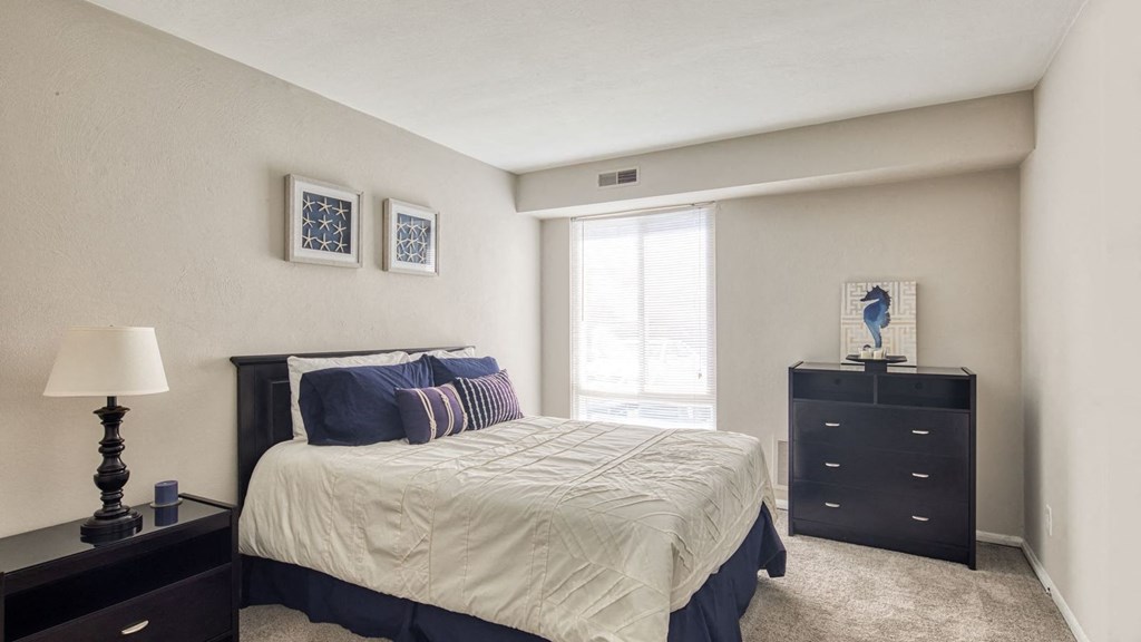 a bedroom with a bed and a dresser and a window at Bayville Apartments, Virginia