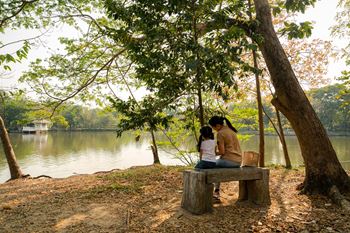 A couple sitting on a bench by a lake.