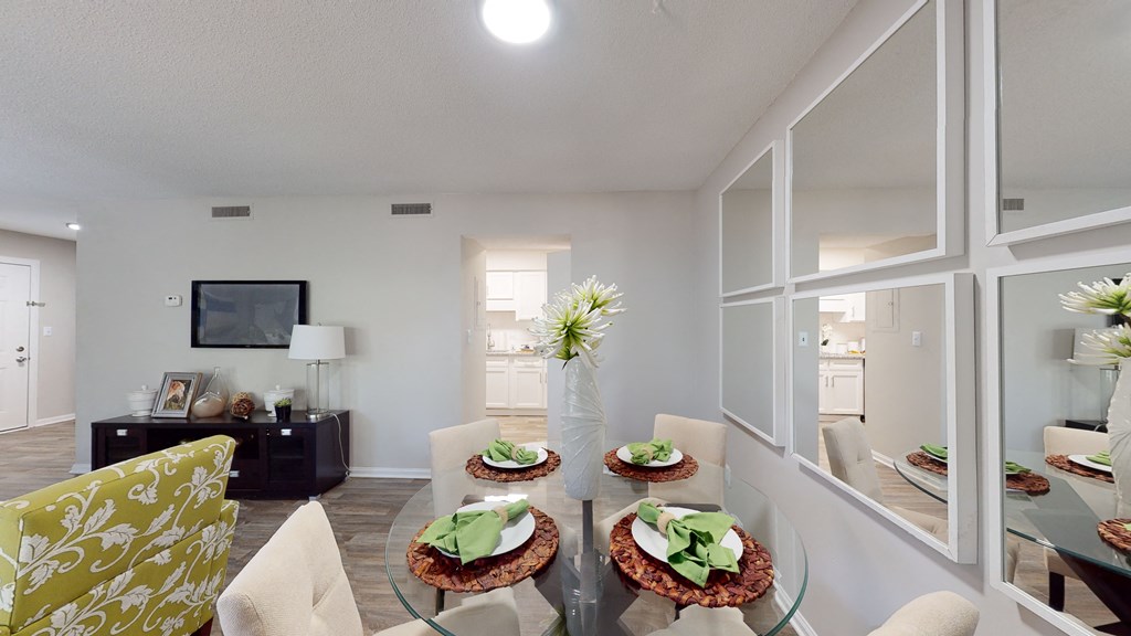 a living room with white walls and a glass table with three plates of food on it