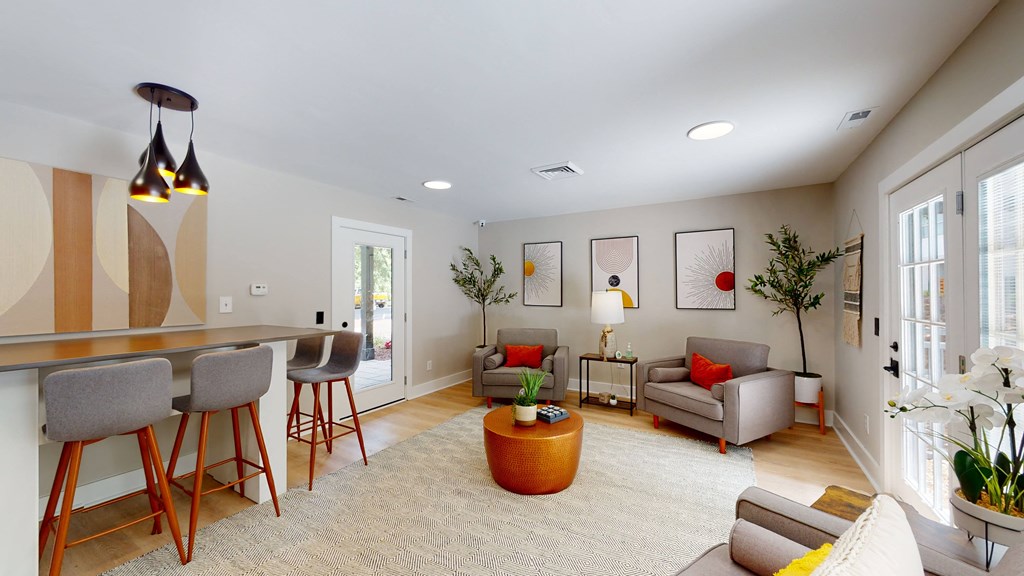 a living room with gray walls and a kitchen with a bar