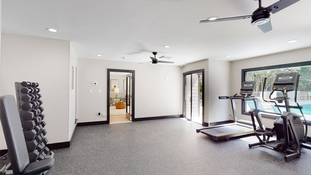a workout room with treadmills and a treadmill