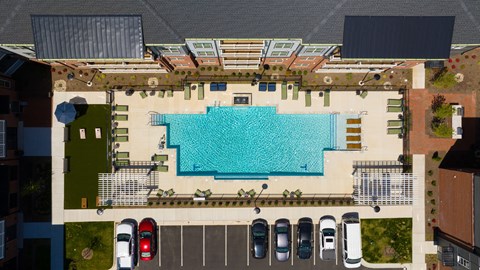 An aerial view of a pool surrounded by a parking lot.