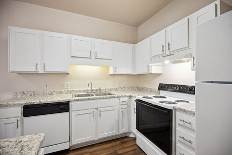 A kitchen with white cabinets and appliances.