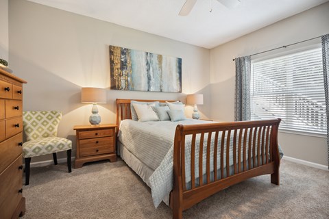 a bedroom with a bed and a chair and a window