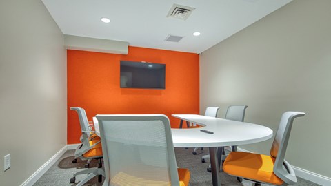 A conference room with a white table and chairs.