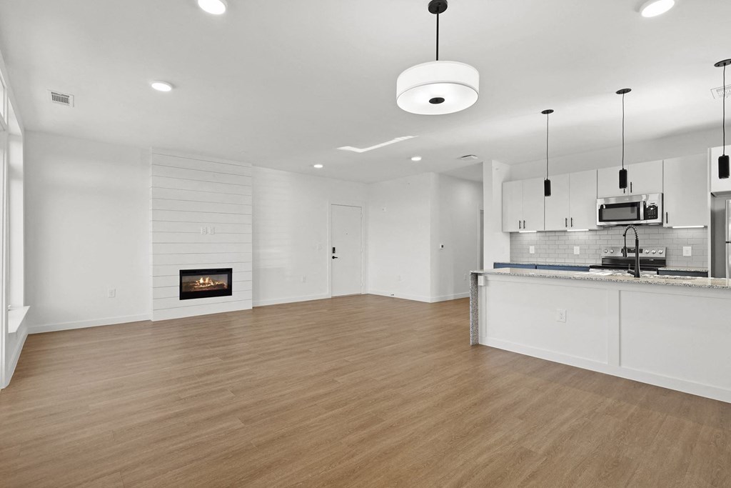 A modern kitchen with a fireplace and wooden floors. at Terraces at High Mountain, Huntsville