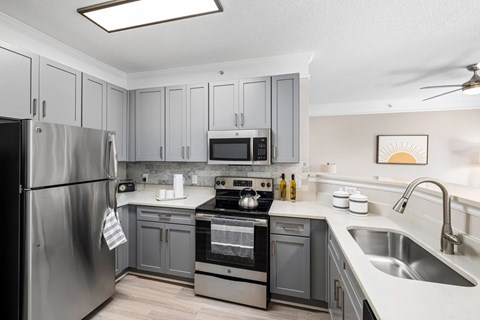 A modern kitchen with a stainless steel refrigerator and a stove top oven.