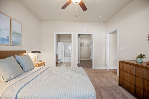 A bedroom with a large bed and a ceiling fan.