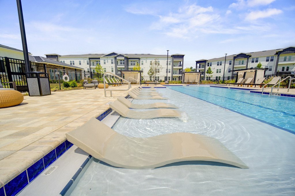A large outdoor swimming pool with sun loungers.