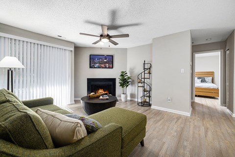 A living room with a green couch and a fireplace.
