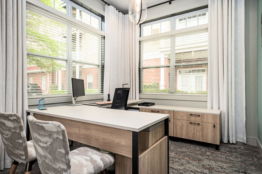 A room with a desk, chair, and two monitors.