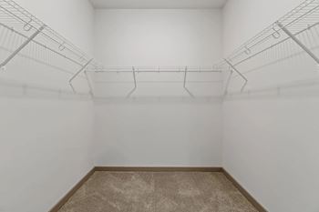 a white room with wire shelving on the wall and a carpetat Metropolis Apartments, Glen Allen Virginia