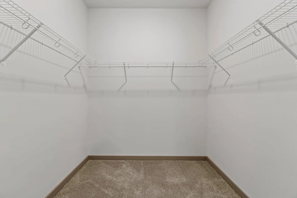 a white room with wire shelving on the wall and a carpetat Metropolis Apartments, Glen Allen, 23060