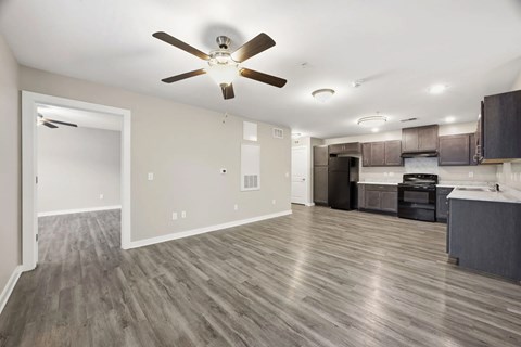 A room with a ceiling fan and wooden flooring.