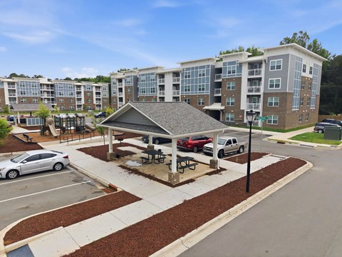 A covered picnic area in front of apartment buildings.