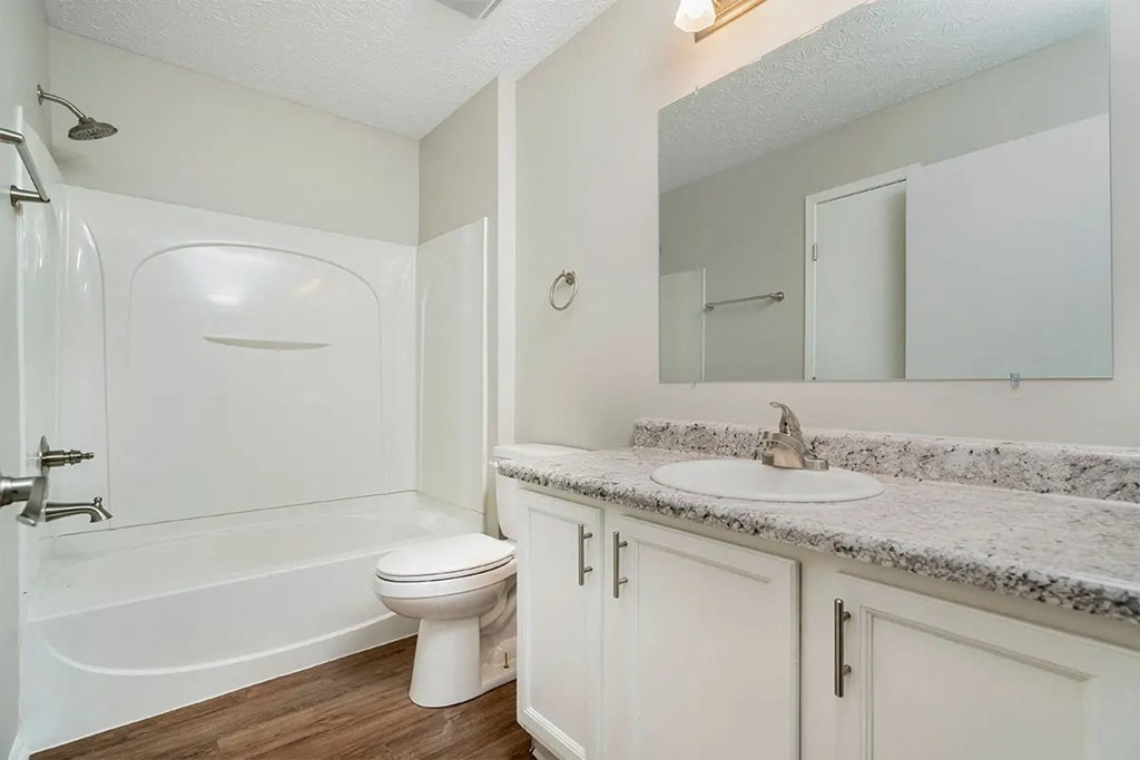 A white bathroom with a toilet, sink, and bathtub.