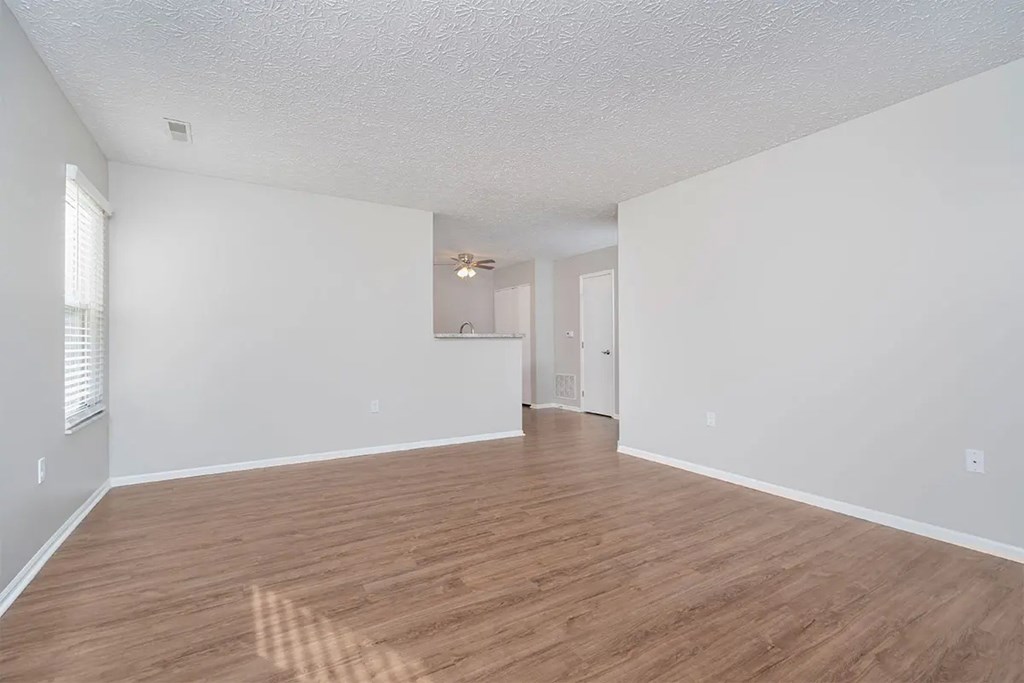 A room with wooden flooring and white walls.