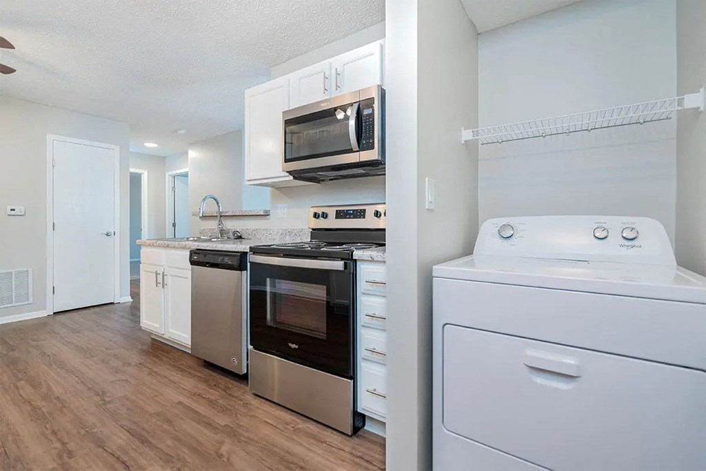 A white kitchen with a white dishwasher and a white dryer.